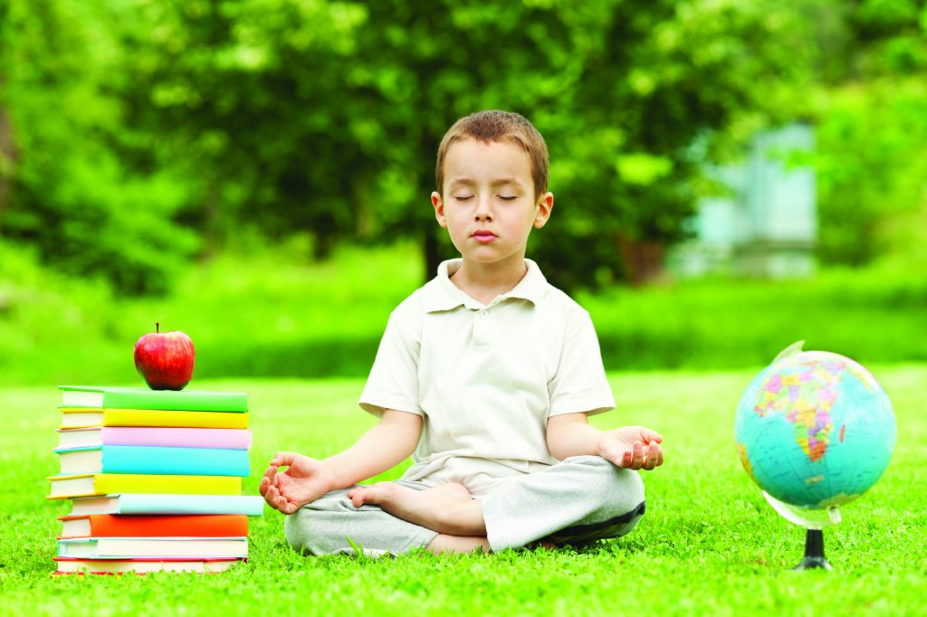 Little boy in zen meditation preparing to be good student